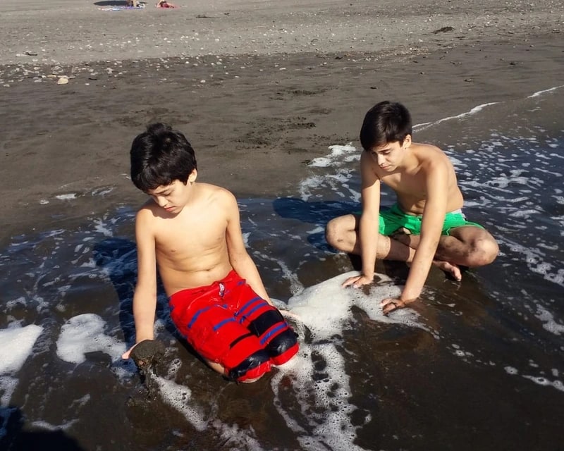 Carlos y Francisco de niños, jugando juntos en la playa